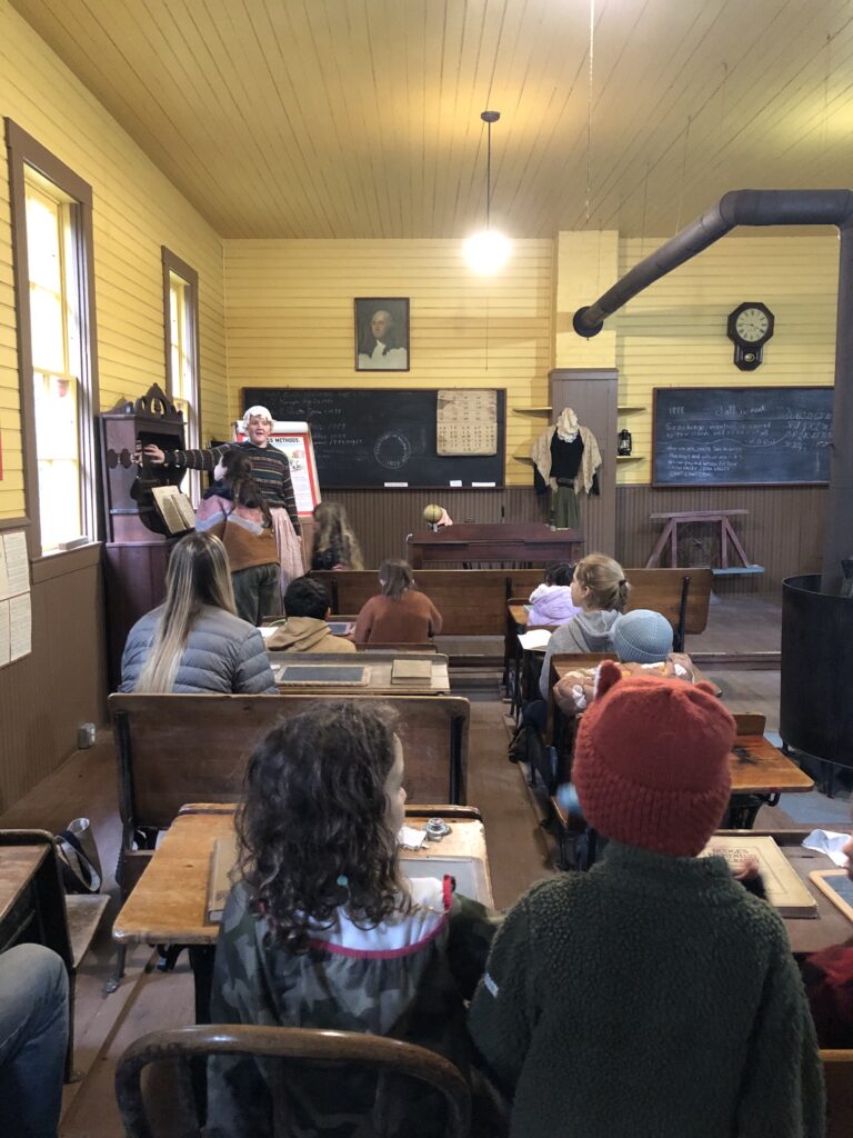 Viewed from behind, a group of Salmonberry students at Crow valley School Museum